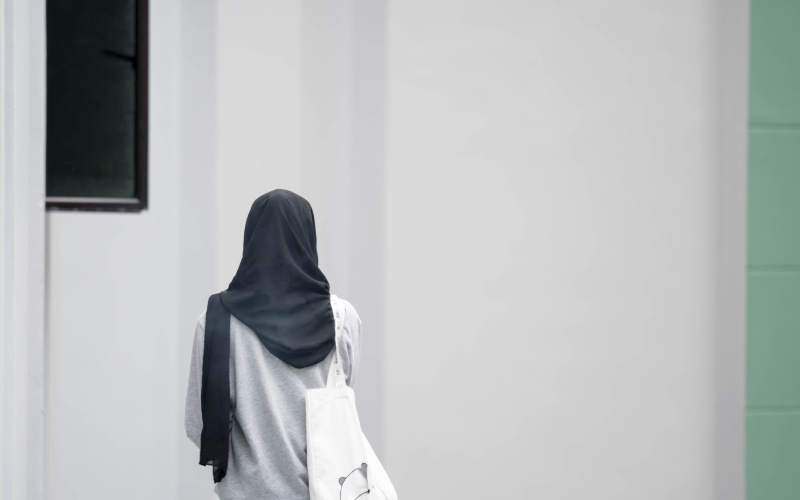 Mädchen mit Kopftuch, von hinten fotografiert